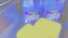 two bottles of detergent sitting next to each other on a counter with yellow sponges