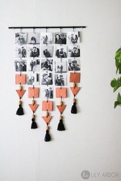 a wall hanging with photos and tassels attached to it's sides on a white wall