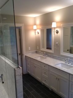 a bathroom with two sinks and a walk - in shower next to a glass door