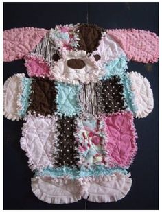 the teddy bear is made out of many different pieces of fabric and has pink, blue, black, white, and brown ruffles on it's chest