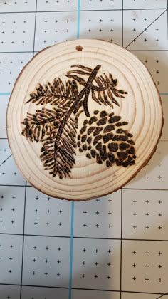 a piece of wood with pine cones and leaves on it sitting on a tile floor