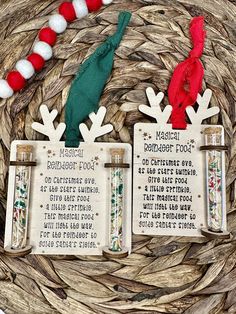 two christmas tags with words on them sitting next to a wreath