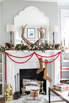 a christmas mantel with stockings and deer antlers on it