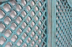 an old blue metal fence with holes in it