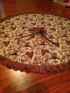 a round table cloth with elephants and giraffes on it sitting on top of a wooden floor