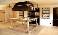 a kitchen with an island, stove and oven in the middle of it's room