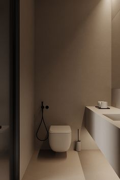 a white toilet sitting next to a bathroom sink under a light on the side of a wall