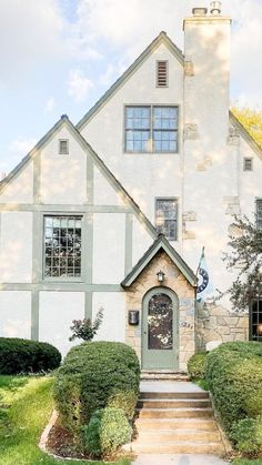 a white house with a green door and steps leading up to the front entrance area