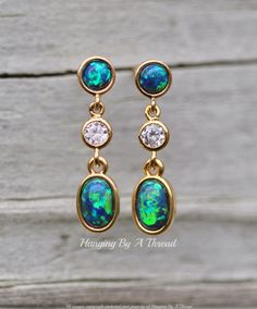 "Gorgeous new earrings made using premium opal components and CZ jewels. The earrings feature 5mm opal stud, that is blue green in color. It connects to a bezel CZ jewel, and an opal charm in the same teal blue color. All components are 14K gold plated and are nickel and lead free. A stud is located at the upper back of the top link. Total earring length is 7/8\". ** Nickel and lead free"