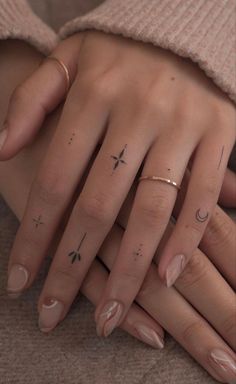 two hands with tattoos on their fingers and one has a star, moon and crescent