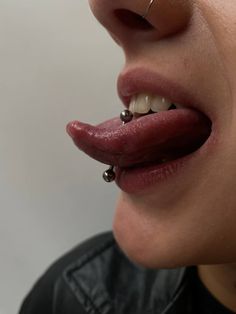 a woman with piercings on her nose and tongue