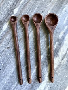 three wooden spoons sitting next to each other on top of a marble countertop