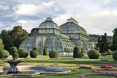 a large glass house surrounded by lots of flowers