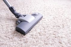 a carpet cleaning service logo with a vacuum on top of the carpet and an image of a person using it