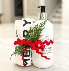 a bottle of soap with a red ribbon tied around it