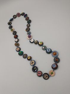 This handmade necklace is made of once-used buttons with colorful glass beads strung and knotted through.  The length of the necklace is 25 inches. Diy Button Necklace, Button Diy Crafts, Button Jewelry Diy, Trinket Ideas, Buttons Necklace, Thrift Inspo, Wishlist 2024, Button Necklace, Diy Buttons