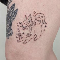 a woman's thigh with an image of two cats and a bird on it