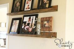 some pictures are hanging on the wall with wooden shelves above them and framed photos below