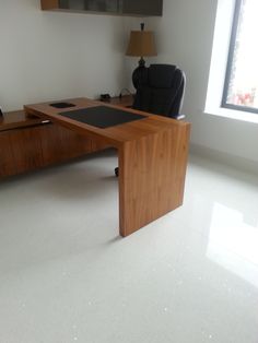 an office desk in the middle of a room with a chair and lamp on it