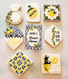 some decorated cookies are sitting on a white table top with blue and yellow designs around them