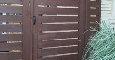 a brown wooden gate next to a house