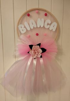 a pink and white wall hanging with the word'blingo'on it