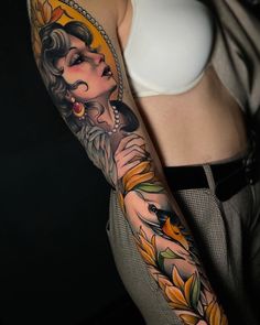 a woman's arm with tattoos on it and an orange flower in the center