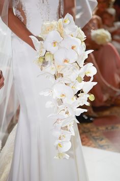 a bride holding a bouquet of white orchids