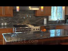 a kitchen with marble counter tops and stainless steel appliances