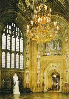 an ornate building with chandelier and statues in the center, surrounded by stained glass windows