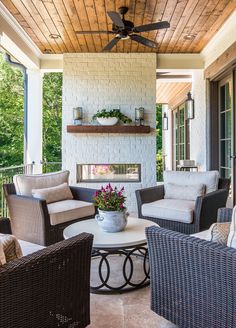 an outdoor living area with wicker furniture and a ceiling fan on the outside wall