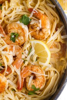 pasta with shrimp and parmesan cheese in a skillet on a white surface