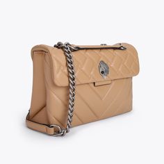 Crafted from a luxury camel leather, the Kensington Purse has alternate stitching across the front with gunmetal detailing on the chain strap and iconic jewelled eagle head embellishment. Black lined interior with two separated compartments.p6.6in (H), 10in (L), 3in (D)Strap drop cross body: 43.7inchStrap drop shoulder: 25inchAntiqued silver chain strap with two padded leather insertsDuo magnetic snap closure hidden under flapSilver foil embossed logo on the backCan fit phones up to 7 inchesTwo interior compartments with small internal lining pocketOuter: Lambskin leatherInterior: Monogrammed interior liningStyle number: 1470448109 London Bags, Eagle Head, Across Body Bag, Crossbody Tote, Day Bag, Kurt Geiger, Quilted Leather, Shoulder Purse, Women Accessories Bags