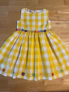 Yellow Large Checked Flowy Fabric, Full Skirt with Embroidered Flower Trim. Fits Sizes: 5-6, Below the Knee. Always 1 of a Kind. Playful Yellow Dress For Dress-up, Cute Yellow Dress For Garden Party, Playful Gingham Dress For Spring, Spring Playful Gingham Dress, Spring Gingham A-line Dress, Yellow Summer Dress For Dress-up, Spring Cotton Dress With Floral Applique, Summer Yellow Dress For Dress-up Occasions, Cute Yellow Sundress For A Garden Party