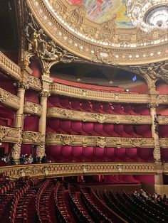 an ornately decorated auditorium with red seats