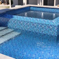 an empty swimming pool with blue tiles on the side and steps leading up to it