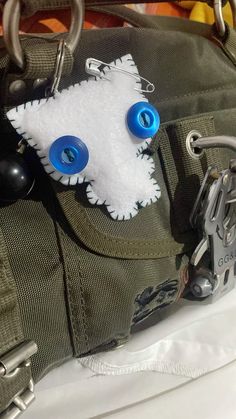 a close up of a bag with two blue eyes and a white furry animal on it