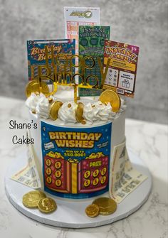 a birthday cake that is on top of a table with money and cards in it