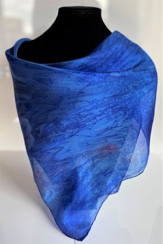 This hand painted silk scarf is made from luxurious and light-weight paj silk. This square scarf is finished with hand sewn edges, and is suitable for evening or day wear. This size square scarf is particularly suitable for wearing as a neck kerchief. Painted by Acacia Silks Tasmania, this unique scarf is impossible to replicate. The dyes used to paint this scarf have been fixed and the easy-care instructions are supplied with the item. Blue Satin Silk Scarf For Gift, Blue Satin Silk Scarf As Gift, Blue Square Summer Scarves, Blue Satin Scarves, Elegant Blue Shawl For Summer, Elegant Summer Blue Shawl, Elegant Blue Summer Shawl, Summer Silk Scarf With Satin Finish, Blue Square Scarves For Gifts