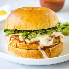 a sandwich with meat, cheese and lettuce on a white plate