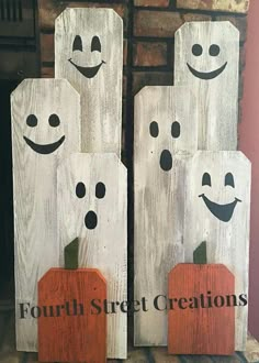 two wooden blocks with faces painted on them, one has a pumpkin and the other is a ghost