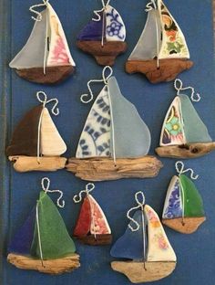 a group of small sailboats hanging on a wall