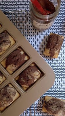 some cupcakes are sitting in a muffin pan next to a jar of peanut butter