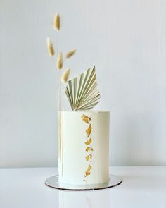 a white cake with gold leaf decoration on top