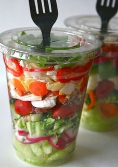 an image of a salad in a plastic container with a fork stuck into the jar