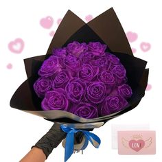 a bouquet of purple roses in a black paper wrapper