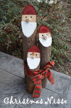 three wooden logs with santa's faces on them and the words, christmas nisse