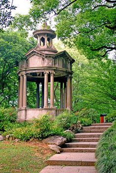 a gazebo in the middle of a park with steps leading up to it