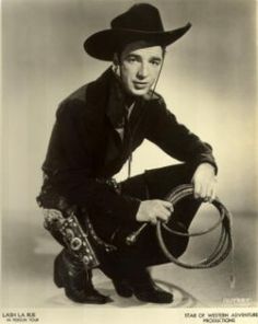 a black and white photo of a man with a cowboy hat holding a lasso