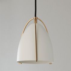 a white and gold pendant light hanging from a ceiling fixture with black cord attached to it